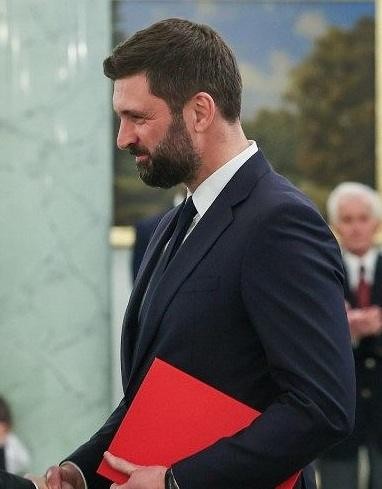 Otwarta książka filozoficzna leżąca na drewnianym biurku, symbolizująca akademickie wykształcenie i pasję do filozofii.