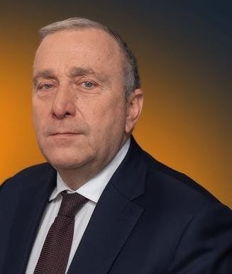 Grzegorz Schetyna podczas wystąpienia publicznego, z gestykulacją, na tle rozmazanego tłumu lub medialnej ścianki.