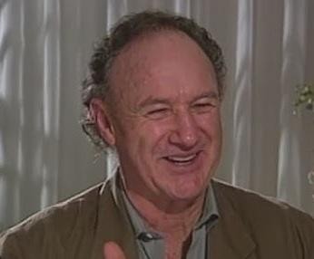 Gene Hackman w starszym wieku, zamyślony, z pędzlem w dłoni, w ciepłym świetle, ukazujący jego mądrość i artystyczną duszę.