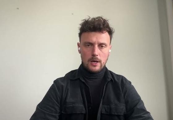 Łukasz Grabarczyk studiujący medyczne materiały, symbolizujące jego wykształcenie i kwalifikacje.