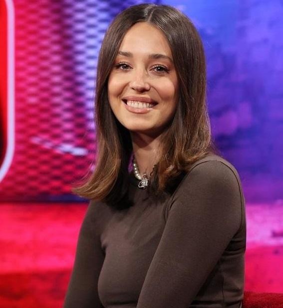 Alt: Izabella Krzan jako prezenterka telewizyjna, w profesjonalnym studiu, wyglądająca pewnie i angażująco.
