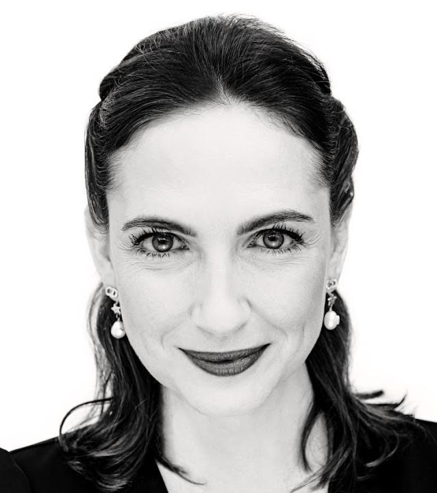 Anna Cieślak na planie filmowym, w skupieniu obserwująca monitor lub rozmawiająca z ekipą, ukazująca profesjonalizm i zaangażowanie w pracę.