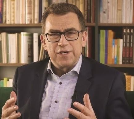 Alt: Maciej Orłoś w swobodnej pozie, symbolizującej jego wszechstronność i działalność poza telewizją.