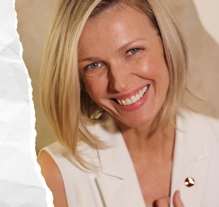 Magda Mołek w studio telewizyjnym, dynamicznie prowadząca program, ubrana w elegancki strój, z lekko zamazanym tłem studia.