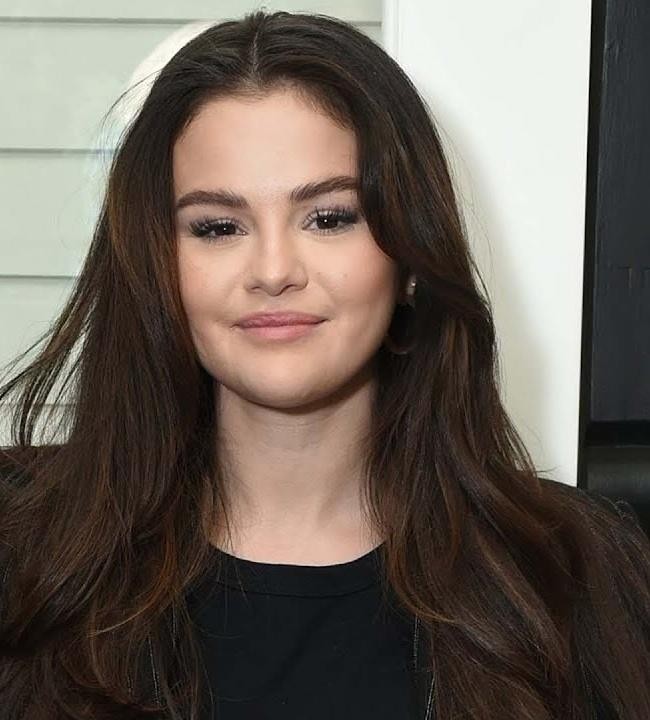 Selena Gomez na scenie lub w roli aktorskiej, prezentująca swoje osiągnięcia w karierze.